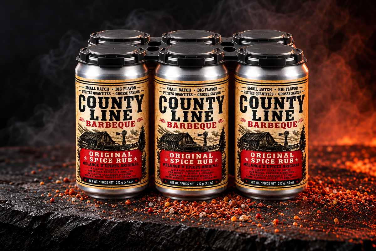 Six cans of County Line Original Spice Rub with a rigid black top carrier on slate stone